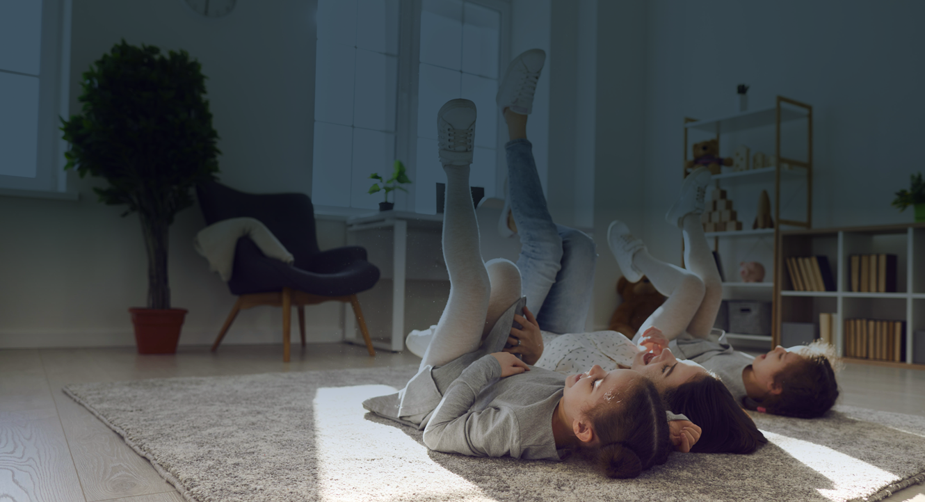 A family of three laying on their backs with their feet up